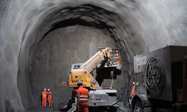ثلاثة مهندسين داخل نفق رمادي اللون يقومون بتمديد أسلاك المتفجرات المزروعة في مقدمة النفق من أجل تفجيره