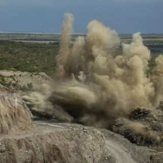 تفجير جبل صخري بواسطة المتفجرات المزروعة من قبل مهندسين من أجل تفتيت الصخور، وتظهر الرمال والصخور المتطايرة بسبب عملية التفجير