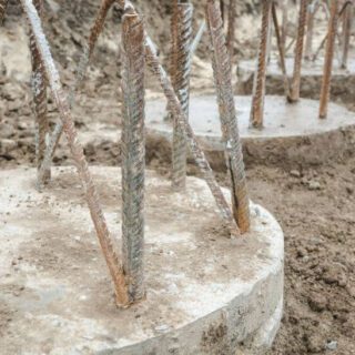 أوتاد اسمنتية دائرية الشكل مبنية داخل الأرض وتخرج منها قضبان حديدية