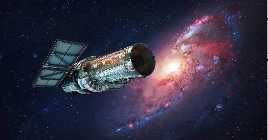 تلسكوب هابل في الفضاء ويظهر خلفه مجرة لونها أحمر