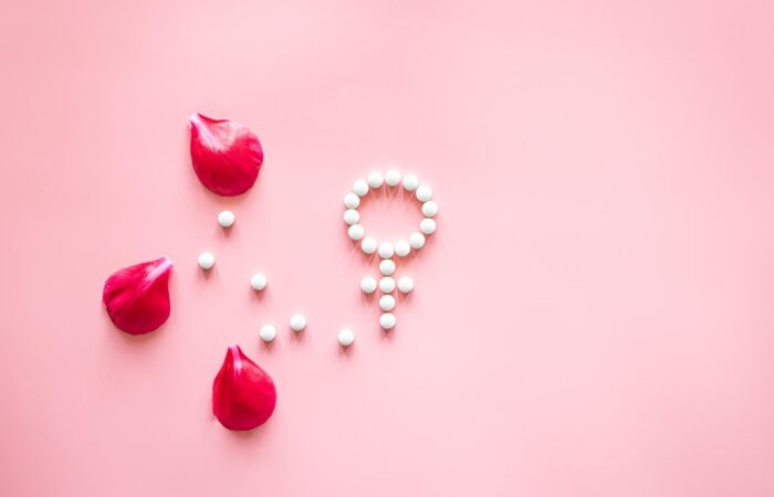 شعار الجنس الأنثوي على خلفية زهرية وبجانبه ثلاث ورقات من وردة جورية حمراء