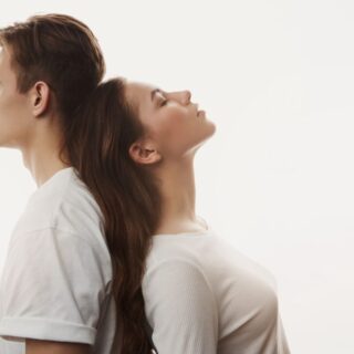 فتاة وشاب يسند كل منهما ظهره على الأخر وهما مغلقين أعينهم دلالة على الحزن بسبب العقم