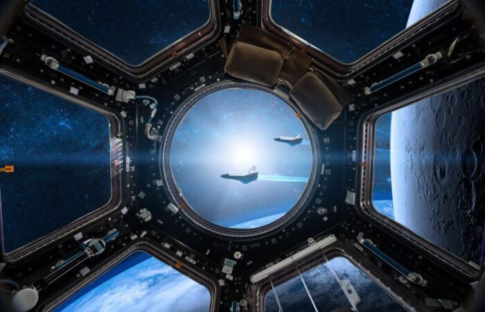 مركبة فضائية جانب القمر ويظهر من خلال نافذتها الدائرية سفينتين فضائيتين تسيران بسرعة