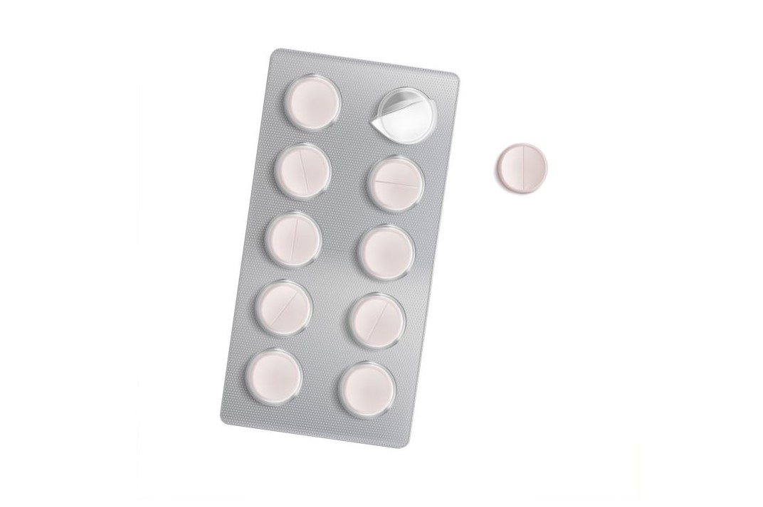 ظرف أقراص دواء الباراسيتامول لونه فضي مع حبة بيضاء اللون جانبه على خلفية بيضاء