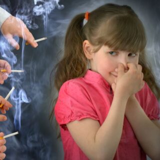 فتاة صغيرة ترتدي قميص أحمر تقوم بسد أنفها بسبب تدخين العديد من الأشخاص من حولها للسجائر