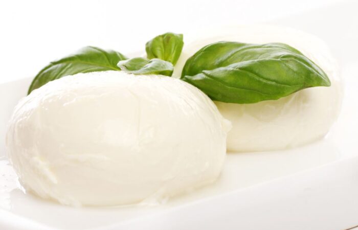 جبنة كروية بيضاء اللون بينهما ورقة ريحان خضراء