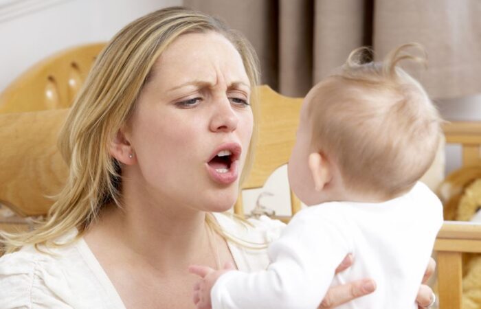 امرأة بالغة شقراء تقوم بهز طفلها الرضيع بعنف وتصرخ في وجهه