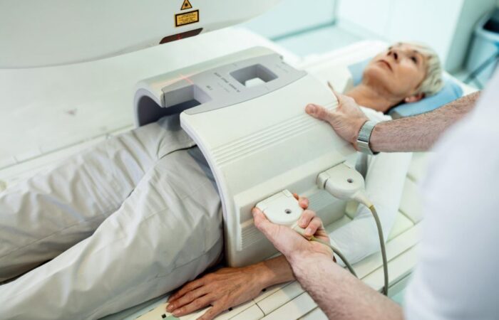 طبيب يقوم بوضع جهاز التصوير بالأشعة على بطن امرأة بالغة من اجل تشخيص المرض