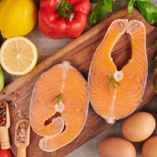 شرائح من السمك بجانب الفليفلة الحمراء والليمون الأصفر ومكسرات وبيض