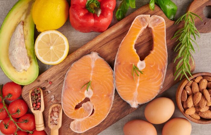 شرائح من السمك بجانب الفليفلة الحمراء والليمون الأصفر ومكسرات وبيض