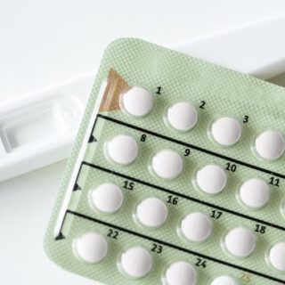 حبوب منع الحمل بيضاء اللون داخل ظرف أخضر