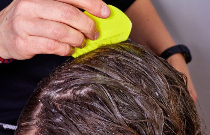 ام تقوم بتمشيط شعر ابنتها بمشط أصفر اللون