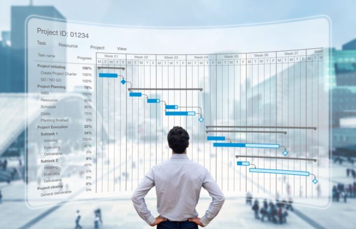 رجل بالغ يقف أمام شاشة كبيرة بها خطوط بيانية