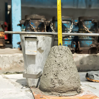 عامل يقوم بقياس ارتفاع كتلة طينية على شكل مخروط بني اللون