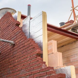 جدار قرميدي خلفه مادة فلينية صفراء ويسند هذا الجدار من الجانب قضيبين معدنيين