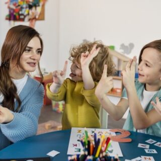 مُدرّسة تقوم بتعليم الأولاد على الأحرف والأرقام الإنكليزية