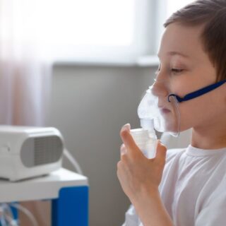 صبي صغير يضع قناع أكسجين على وجهه وينظر للأسفل