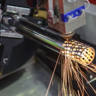 آلة تقوم بإصدار شعاع أصفر يقوم بثقب اسطوانة معدنية طويلة أسفلها