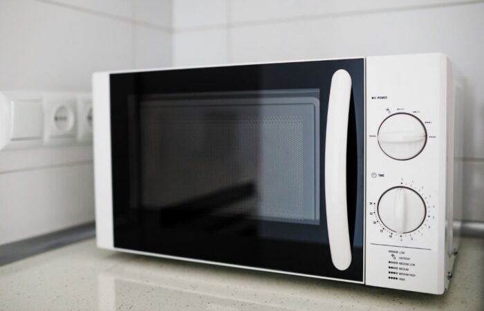 جهاز الكتروني في المطبخ مربع الشكل واجهته سوداء لامعة وعلى جانب الجهاز توجد مفاتيح تحكم دائرية