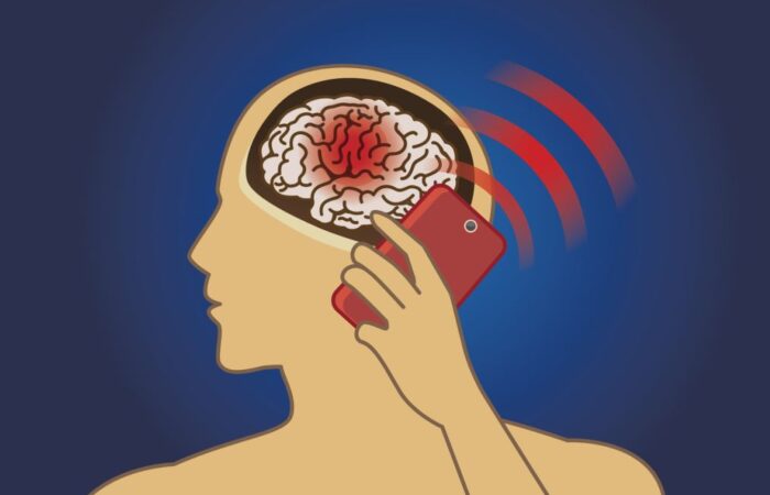 رسم توضيحي لشخص يضع الهاتف الخلوي أمام رأسه وتوجد بقعة حمراء على الدماغ وإشارات تخرج من الجهاز الخلوي