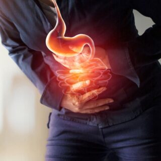 شخص بالغ ينحني للأمام ويضع يديه على بطنه