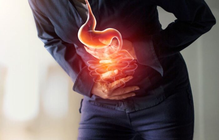 شخص بالغ ينحني للأمام ويضع يديه على بطنه