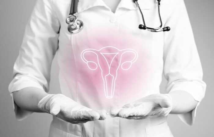 طبيبة ترتدي كنزة بيضاء وسماعات تمد يديها للأمام وتظهر على يديها رسمة للجهاز التناسلي عند المرأة