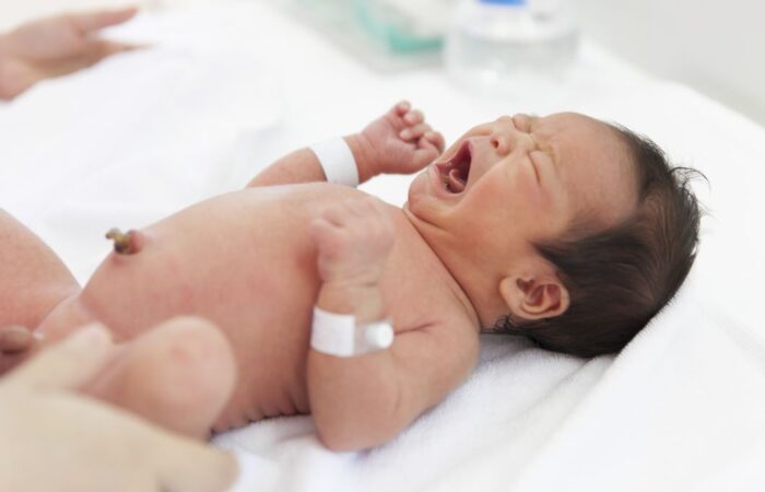 طفل رضيع ممدد في سريره وهو يبكي