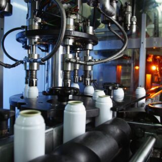 جهاز صناعي في المعمل أسفله توجد علب بيضاء اسطوانية الشكل