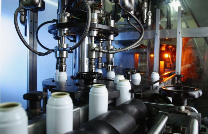 جهاز صناعي في المعمل أسفله توجد علب بيضاء اسطوانية الشكل