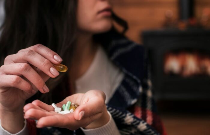 امرأة بالغة تضع في يدها مجموعة من الحبوب وتمسك باليد الأخرى بحبة شفافة اللون