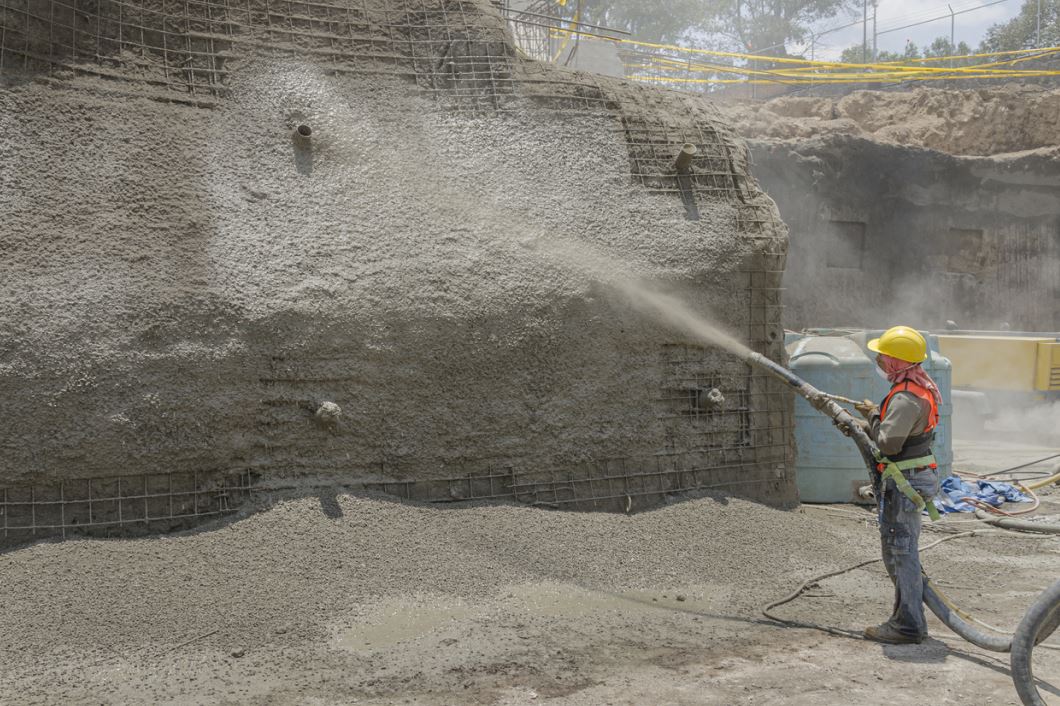 عامل بناء برش الخرسانة على جدار في موقع العمل