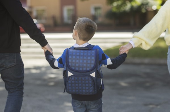 طفل يرتدي حقيبة مدرسية وهو ذاهب للمدرسة