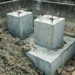 كتلة خرسانية لاساسات المنزل مدفون نصفها بالرمال