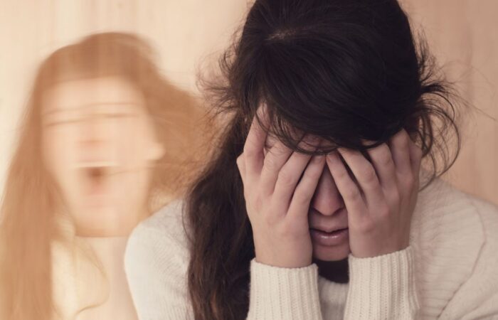 امرأة تضع يديها على وجهها وبجانبها تظهر صورة مكررة لها وهي تصرخ