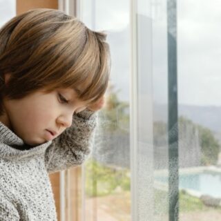 صبي ينظر من خلف النافذة
