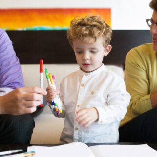 صبي صغير يقوم باللعب بين رجل وامرأة