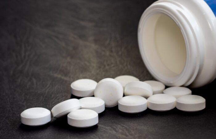 حبوب دواء بيضاء اللون بجانب علبة واء
