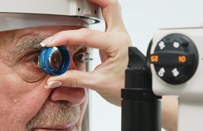 طبيب يقوم بفحص عيون رجل مسنّ