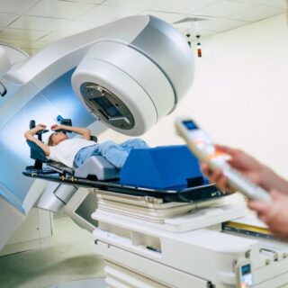 فتاة مستلقية على سرير جهاز طبي حوله جهاز ماسح ضوئي يدور