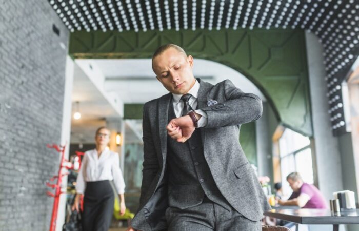 رجل يرتدي بدلة رسمية وينظر لساعة يده