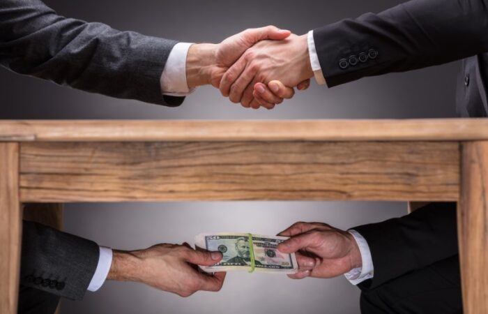 تصافح الأيدي فوق الطاولة وتبادل الأموال تحت الطاولة