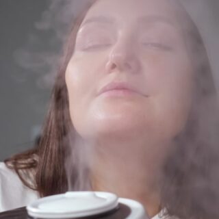 امرأة مغمضة العينين تستنشق بخار متطاير