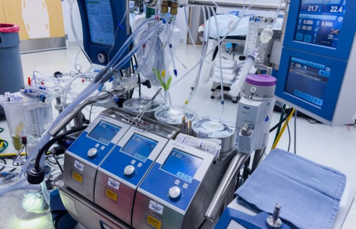 جهاز طبي عليه العديد من شاشات المراقبة وموصل به أنابيب شفافة