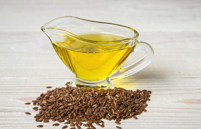 بذور بنية اللون وكأس مملوء بالزيت