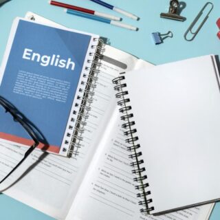 كتب ودفتر مكتوب عليه بالإنكليزية English وأقلام ونظارة طبية