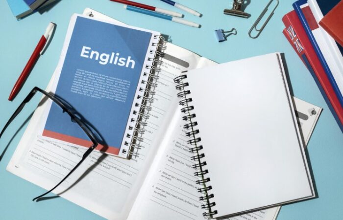 كتب ودفتر مكتوب عليه بالإنكليزية English وأقلام ونظارة طبية