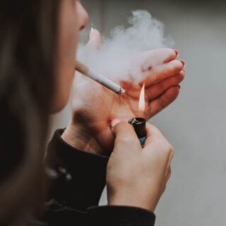 امرأة تشعل سيجارة