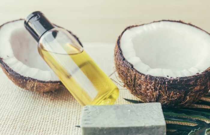 زجاجة بداخلها سائل أصفر اللون وبجانبها ثمرة جوز الهند