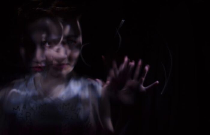 خيال امرأة في المرآة تمد يدها للأمام